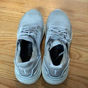 Women’s gray and white Adidas athletic shoes.